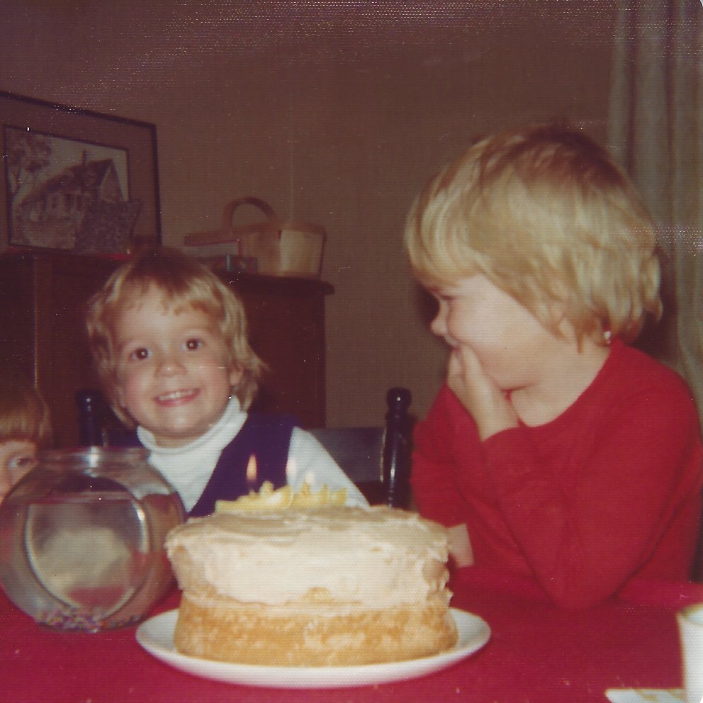 colour photo of small children at table with birthday cake