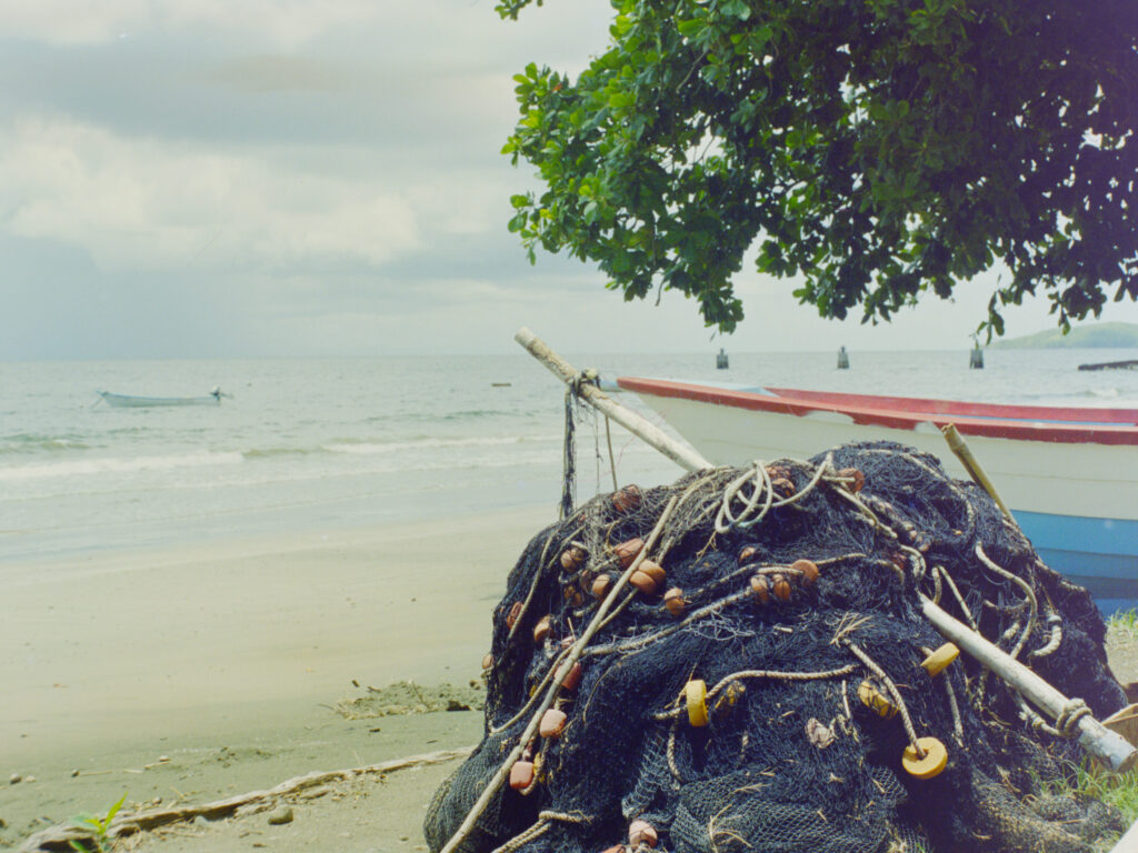 colour photo of fishing nets gathered into a pile on the beach