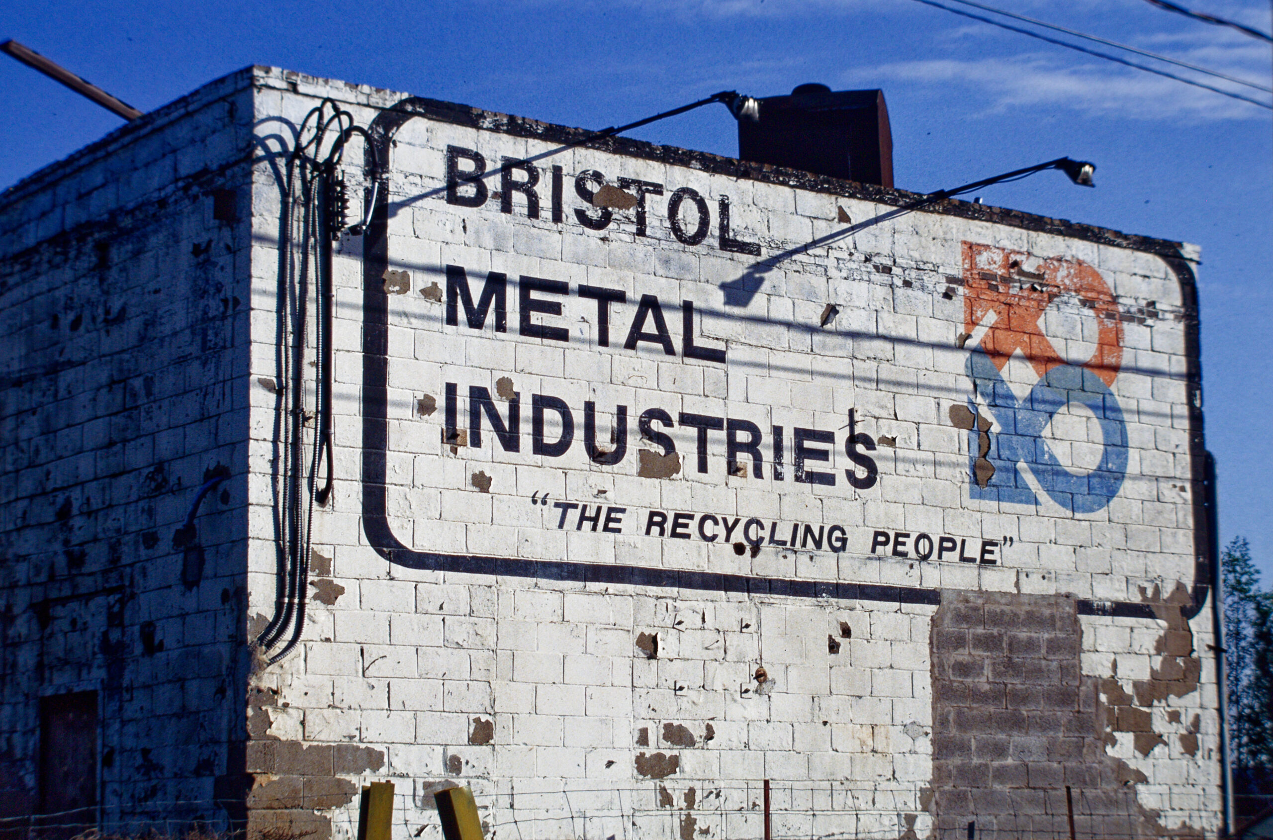 colour photo of a large sign painted on masonry wall, reading "bristol metal industries" and "the recycling people"