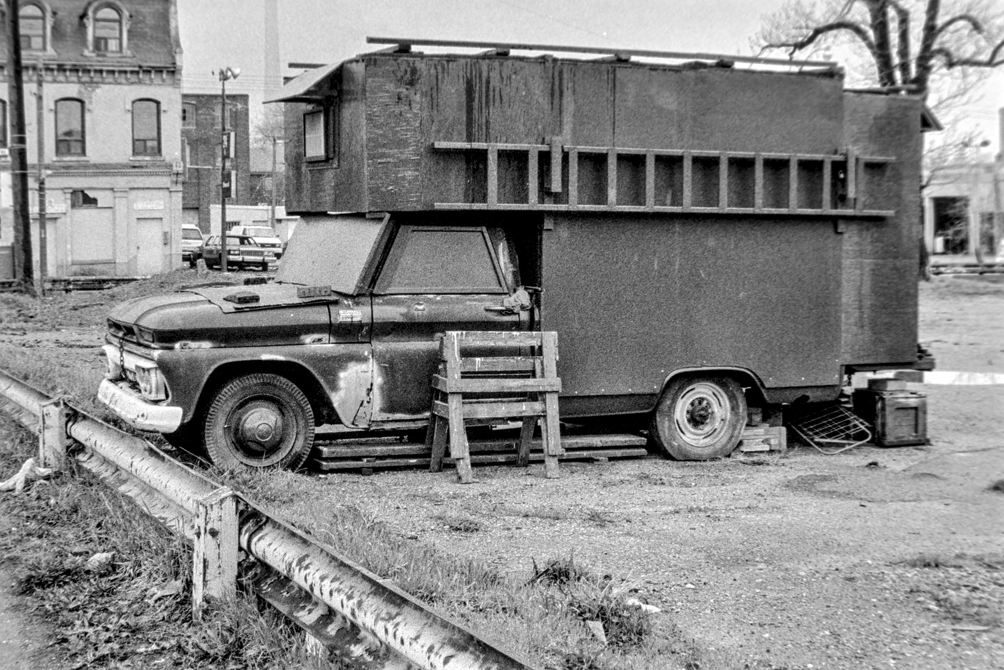 black and white photo of a dilapidated work truck in a parking lot